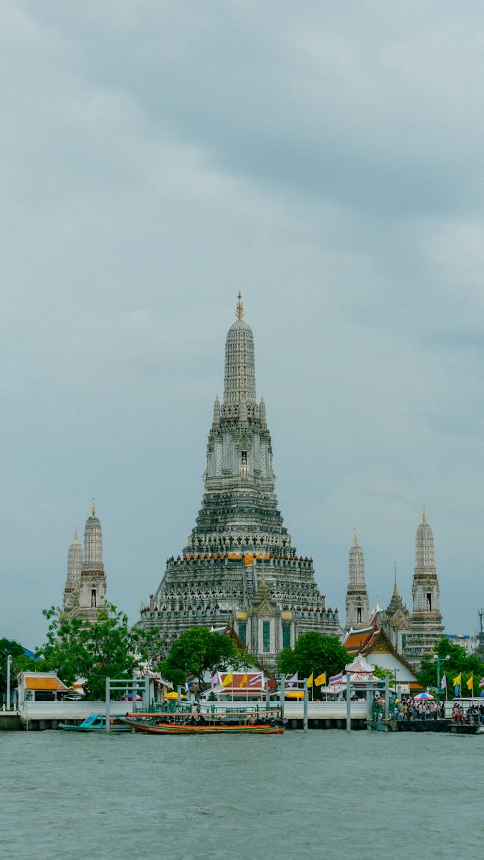 Stunning view of Wat Arun by the Chao Phraya River in Bangkok during the day.