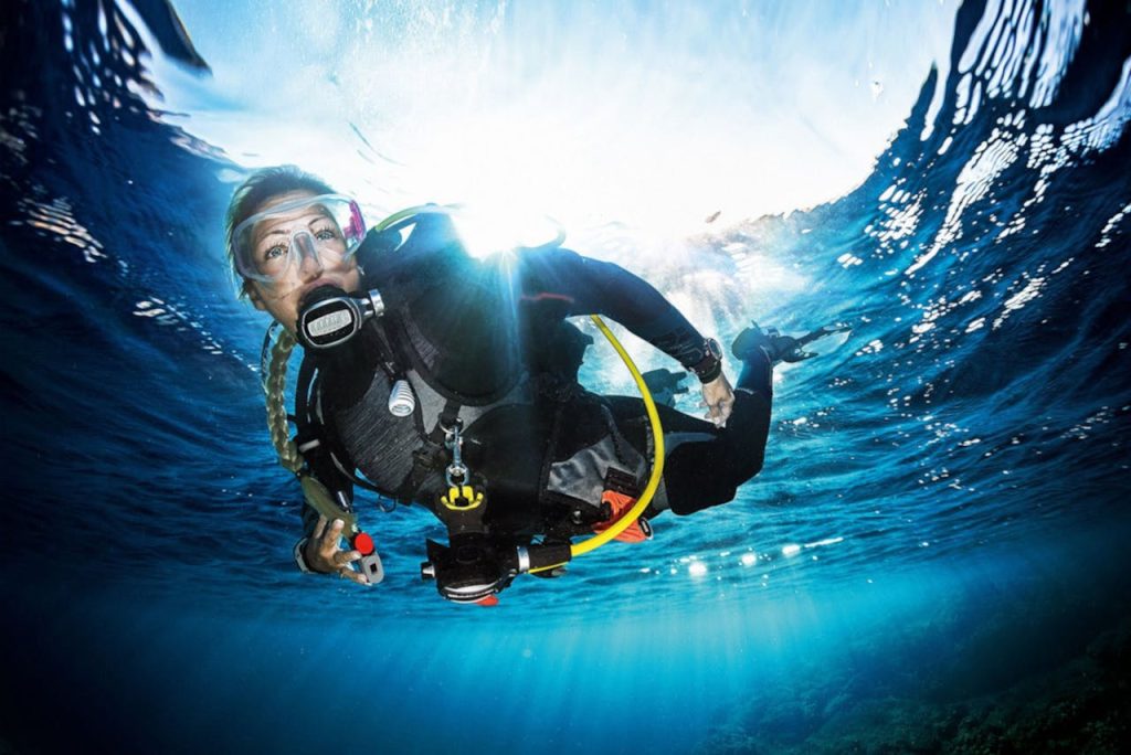 CONTACT A scuba diver explores the clear blue ocean, capturing the vibrant underwater beauty.